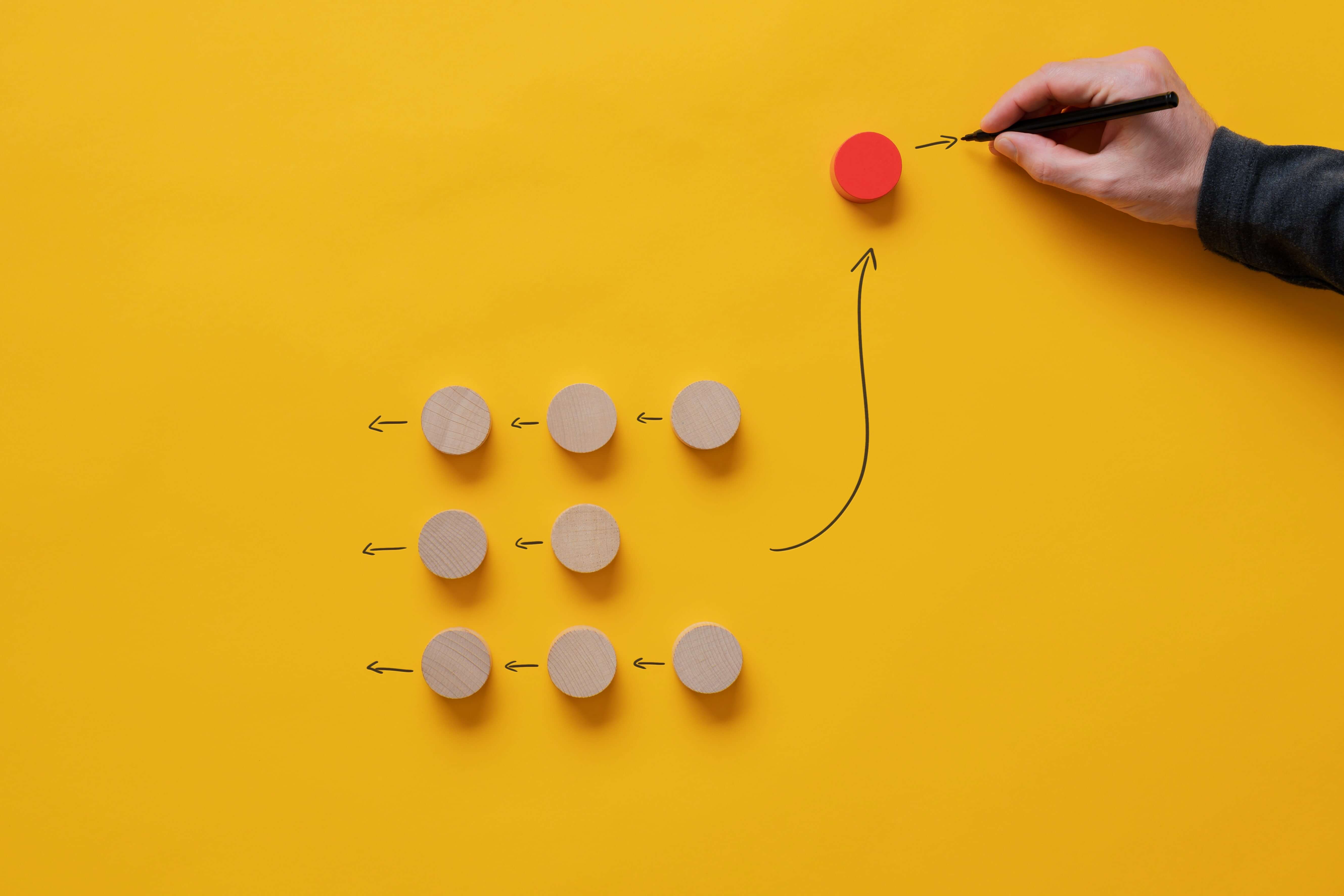 A hand shown designing a sequence of workflow on a yellow background