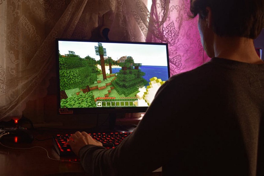 A boy playing minecraft on a computer