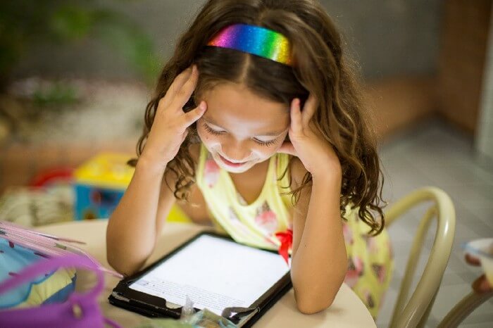 A young girl looking at the ipad with a smile