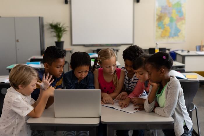 A group of 7 kids involved in discusson in a classroom
